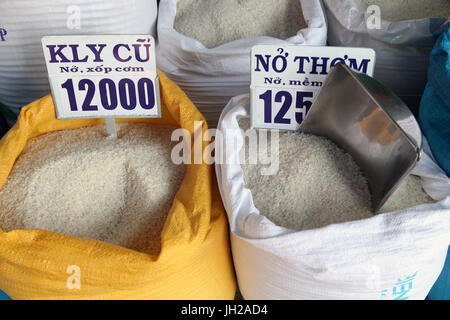 En différentes qualités de riz en vente dans des sacs à un marché en plein air. Le Vietnam. Banque D'Images