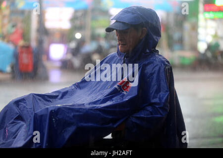 De fortes pluies de mousson. Scooter sur Saigon Street. Le Vietnam. Banque D'Images