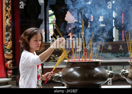 Temple taoïste. Phuoc une pagode de Hoi Quan. Bâtonnets d’encens sur joss stick pot sont en feu et la fument utilisation au respect de la rémunération au Bouddha. Adorateur de bouddhiste Banque D'Images