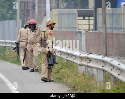 Srinagar, au Cachemire. 12 juillet, 2017. Kashmirn policiers regarde vers les manifestants lors d'affrontements au cours de l'assassinat du rebelle Mohammed Aquib Gul dans une nuit de rencontre avec forces en Budgam district de cachemire. Gul avait rejoint les rangs après l'Aïd. Pendant ce temps, un couvre-feu a été mis en œuvre dans de nombreuses régions de Srinagar à contrecarrer les manifestations. Credit : Muzamil Mattoo/Pacific Press/Alamy Live News Banque D'Images