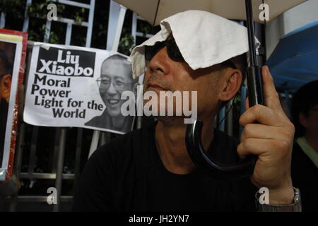 Hong Kong, Chine. Le 13 juillet, 2017. Un manifestant pro-démocratie couvrir la tête avec une serviette sous la chaleur de l'été à l'extérieur du bureau de liaison du gouvernement populaire dans la région, la mise en scène des sit-in pour le dissident chinois, prisonnier politique et la lauréate du Prix Nobel de la paix LIU XIAO BO exigeant Lius publication immédiate Le 13 juillet 2017..Hong Kong.ZUMA/Liau Chung Ren : Crédit Liau Chung Ren/ZUMA/Alamy Fil Live News Banque D'Images