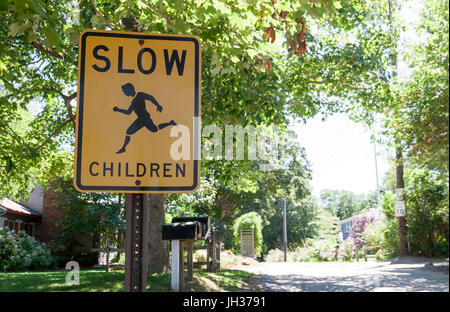 Les enfants lents panneau d'avertissement invitant les automobilistes à ralentir. Banque D'Images