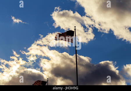 Drapeau américain sur mât agitant au vent contre les nuages, ciel bleu Banque D'Images