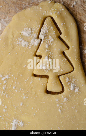 Biscuit de Noël faire concept avec arbre de Noël découper la forme de pâte roulée. Saupoudre de farine sur la pâte et de bois en dessous. Banque D'Images