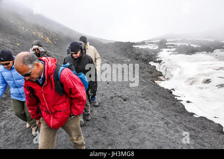 Un guide en tenant un petit groupe de touristes pour une visite du volcan, l'Etna, en Sicile, Italie. Banque D'Images