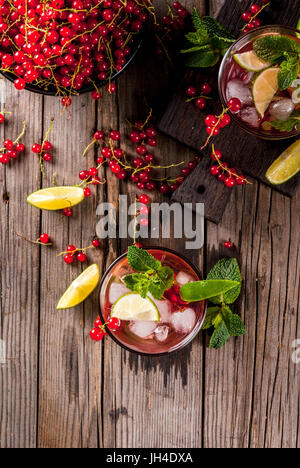 Idées de boissons d'été, des cocktails sains. Le Mojito de lime, menthe et de groseille rouge. Sur la vieille table en bois rustique, avec les ingrédients. Copie Banque D'Images