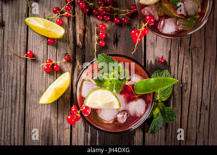 Idées de boissons d'été, des cocktails sains. Le Mojito de lime, menthe et de groseille rouge. Sur la vieille table en bois rustique, avec les ingrédients. Copie Banque D'Images