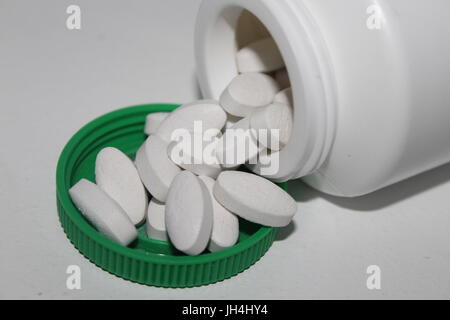 Pilules blanches de répandre de la bouteille Banque D'Images