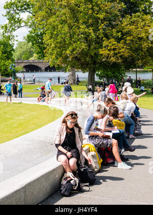 Les personnes bénéficiant de l'ensoleillement, Princess Diana Memorial Fountain, Hyde Park, Londres, Angleterre Banque D'Images