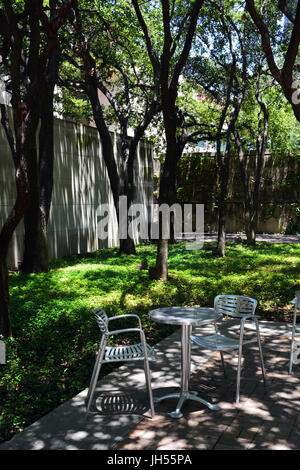 Chaises et tables offrent un cadre paisible pour s'asseoir à l'ombre du Dallas Museum of Art Sculpture Garden. Banque D'Images