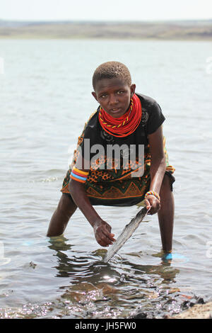 LOIYANGELENI, KENYA - Mai 18. Une fille samburu lave la vaisselle sur le lac au village El Molo à Loyangalani. Crédit : David Mbiyu/Alamy Live News Banque D'Images