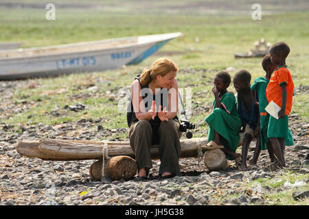 LOIYANGELENI, KENYA - Mai 18. Un touriste discute avec les enfants sur les rives du lac Turkana, au cours du Festival du lac Turkana. Crédit : David Mbiyu/Alamy Live News Banque D'Images