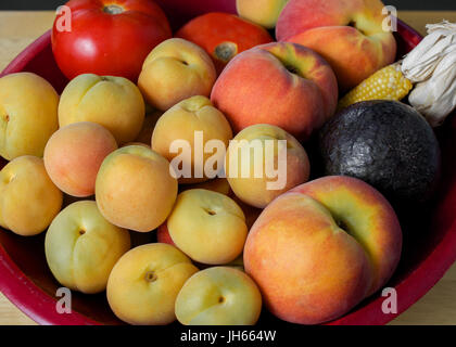 Gros plan sur les fruits récoltés en Californie à la fin de l'été, dans le panier rouge, décoré de blé d'inde Banque D'Images