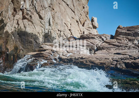 Vagues se brisant sur les roches où le soleil est joint à Cabo San Lucas, Mexique Banque D'Images