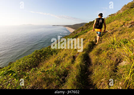 Un randonneur regardant un littoral magnifique vue sur la mer au cours d'un matin d'été qu'il marche sur un sentier du littoral en Australie. Banque D'Images