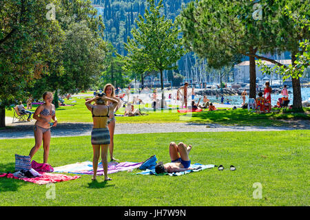 Les gens se détendre dans baie de Riva Del Garda, Lac de Garde, Lombardie Banque D'Images