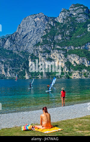 Les gens se détendre dans baie de Riva Del Garda, Lac de Garde, Lombardie Banque D'Images