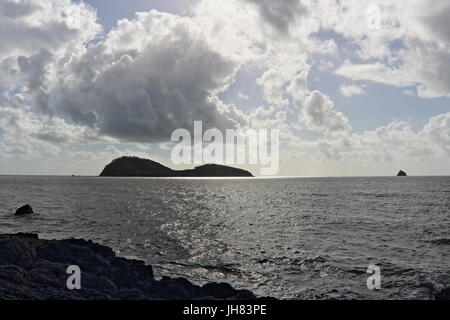 Palm Cove beach considèrent l'exploitation dans le haut de gamme comme la lumière du soleil se reflète sur l'eau sur un matin nuageux Banque D'Images