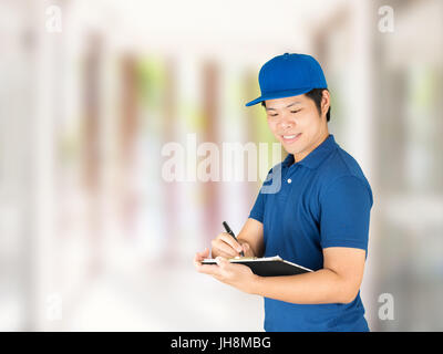 Livraison asiatique homme écrit sur le bloc-notes Banque D'Images