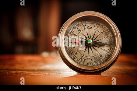 Vintage still life. Vintage boussole se trouve sur une ancienne carte du monde. Banque D'Images