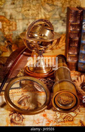 Vintage still life. Vintage loupe réside, montre de poche, livre ancien et astrolabe sur une ancienne carte du monde en 1565. Banque D'Images