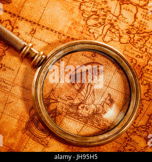 Vintage still life. Vintage loupe se trouve sur une ancienne carte du monde en 1565. Banque D'Images