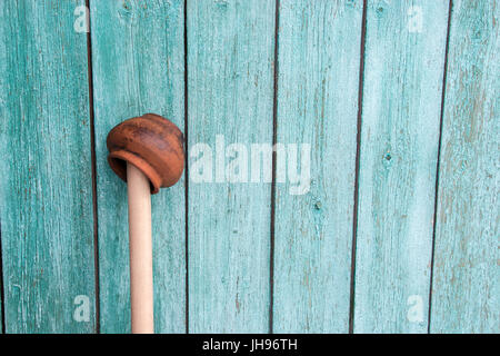 Shabby antique fait main orange pot en argile sur un bâtonnet de bois sur un fond en bois peints. Thème du village. Concept Vintage Banque D'Images