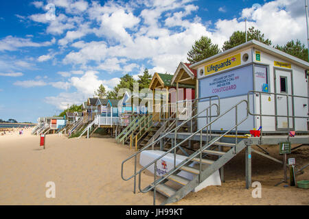 Un poste de garde-côtes HM et rangées de cabines de plage sur une plage de sable à Norfolk, UK qui est fermé représentant une plage qui n'est pas surveillé par des maîtres nageurs. Banque D'Images