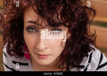 Femme aux cheveux bouclés closeup portrait. Les femmes aux cheveux rouges looking at camera Banque D'Images