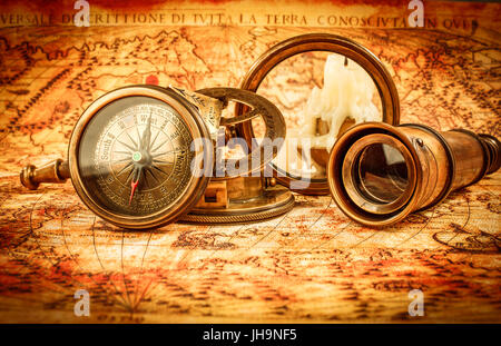 Vintage still life. Vintage loupe et d'une boussole se trouve sur une ancienne carte du monde en 1565. Banque D'Images