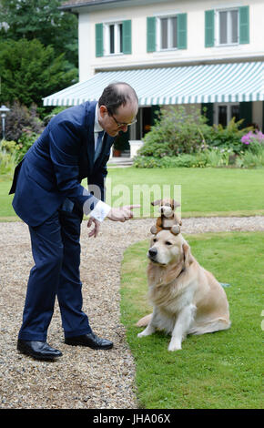 Berlin, Allemagne. Le 13 juillet, 2017. L'ambassadeur britannique à l'Allemagne Sir Sebastian Wood et son épouse Dame Bois Sirinat arrivent avec leur chien Albie pour une séance photo au jardin de la résidence de l'ambassadeur britannique à Berlin, Allemagne, 13 juillet 2017. On a répondu aux questions concernant l'Anniversaire de la Reine, à lieu le 19 juillet avec la présence du duc et de la duchesse de Cambridge. Grande-bretagne's Prince Willian et son wiffe arrivent à Berlin le 19 juillet. Photo : Jens Kalaene Zentralbild-/dpa/dpa/Alamy Live News Banque D'Images