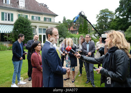 Berlin, Allemagne. Le 13 juillet, 2017. L'ambassadeur britannique à l'Allemagne Sir Sebastian Wood et son épouse Dame Bois Sirinat arrivent avec leur chien Albie pour une séance photo au jardin de la résidence de l'ambassadeur britannique à Berlin, Allemagne, 13 juillet 2017. On a répondu aux questions concernant l'Anniversaire de la Reine, à lieu le 19 juillet avec la présence du duc et de la duchesse de Cambridge. Grande-bretagne's Prince Willian et son wiffe arrivent à Berlin le 19 juillet. Photo : Jens Kalaene Zentralbild-/dpa/dpa/Alamy Live News Banque D'Images