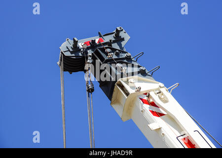 Camion-grue détail boom avec des crochets et des poids au-dessus de ciel bleu Banque D'Images