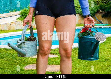 Travaux de jardinage. Femme avec des arrosoirs. Banque D'Images