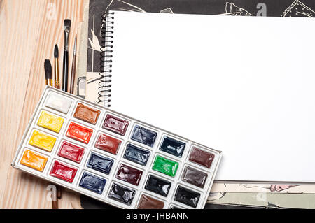 Ordinateur portable blanc, pinceaux et aquarelle sur une surface en bois Banque D'Images