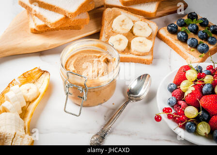 L'été européen et américain traditionnel petit-déjeuner : sandwiches de pain grillé avec du beurre d'arachide, berry, fruits pomme, pêche, myrtille, bleuet, strawberr Banque D'Images