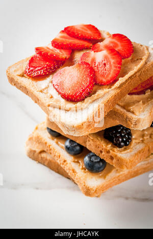 L'été européen et américain traditionnel petit-déjeuner : sandwiches de pain grillé avec du beurre d'arachide, berry, fruits pomme, pêche, myrtille, bleuet, strawberr Banque D'Images