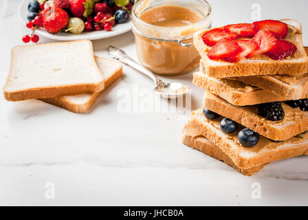 L'été européen et américain traditionnel petit-déjeuner : sandwiches de pain grillé avec du beurre d'arachide, berry, fruits pomme, pêche, myrtille, bleuet, strawberr Banque D'Images