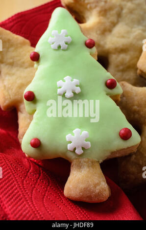 Une sélection de biscuits en forme de Noël (cookies) sur la plaque avec une serviette rouge, surmontée d'iced (dépoli) forme avec décorations. Banque D'Images