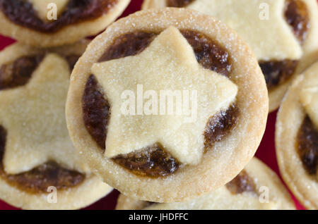 Passage rapprochée sur une assiette empilée avec petits pâtés pour Noël. Style ouvert avec remplissage fruité, exposés en forme d'étoile garnie de pâtisseries. Banque D'Images