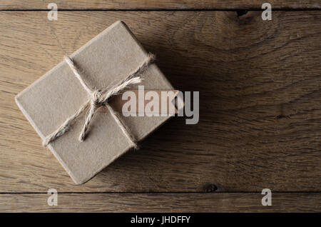 Passage tiré d'un simple, rustique, plain brown boîte cadeau, liés avec de la ficelle et un tag pour copie espace situé sur de vieux bois de chêne bordés. Banque D'Images