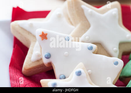 Une sélection de thés et biscuits de Noël décoré, dans l'arbre et l'étoile de formes. Plaqué avec une serviette rouge. Banque D'Images