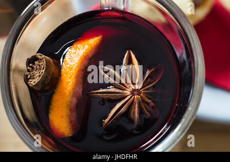 Passage close up (macro) prise d'un verre de vin chaud à la badiane, l'orange et le bâton de cannelle. Serviette rouge et mince pie in soft focus backgroun Banque D'Images