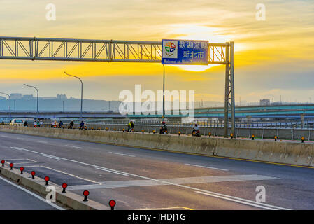 L'autoroute sur un pont avec Bienvenue à nouveau Taipei signer pendant le coucher du soleil Banque D'Images