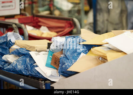 Des sacs postaux d'envoi de petits colis et d'enveloppes sur la courroie du convoyeur à royal mail delivery office Banque D'Images