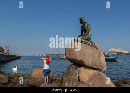 Un garçon à la statue de la petite sirène de Copenhague, Danemark. Banque D'Images