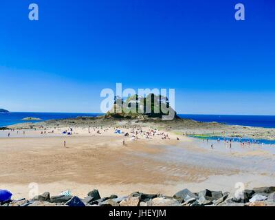 La foule sur la plage à marée basse en été, plage du Guesclin, avec le fort du Guesclin et la Manche en arrière-plan, Bretagne, Bretagne, France. Banque D'Images