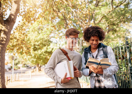 Les étudiants de l'université reading book dans la cour du collège. Les jeunes élèves du collège avec des livres sur la rue. Banque D'Images