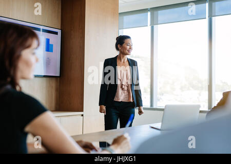 Asian businesswoman expliquant l'intention de collègues dans la salle de conférence. Présentation de l'entreprise en salle du conseil. Banque D'Images