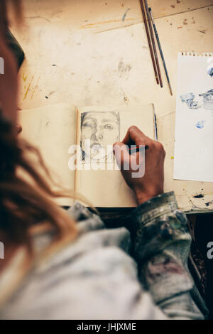 Vue de dessus de femme artiste esquisse sur réserve dans son studio. Peintre de travailler dans son atelier. Banque D'Images